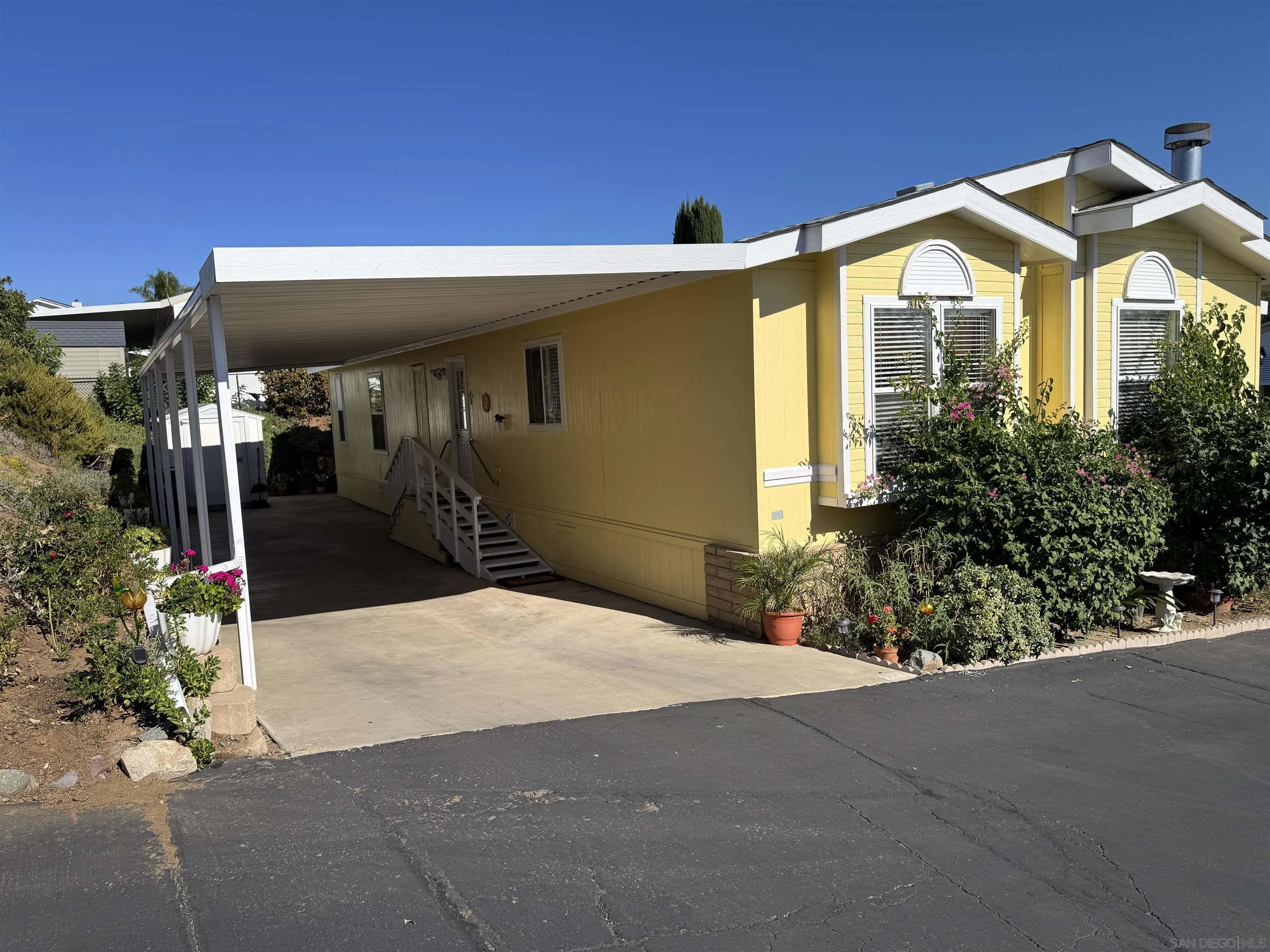 12250 Vista Del Cajon Road, Unit 25 El Cajon, CA 92021 - Photo 37 of 39 a front view of a house with a yard and garage