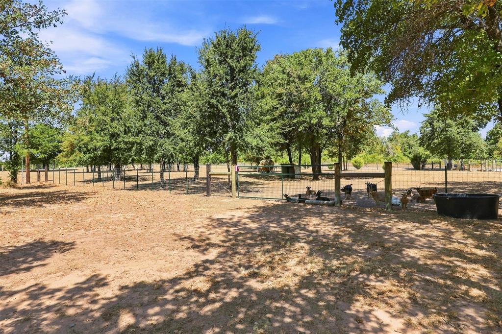 1000 Middleton Road Weatherford, TX 76088 - Photo 23 of 31 Expansive outdoor area featuring mature trees, partial fencing, and a sun-dappled ground surface