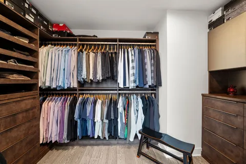 a view of walk in closet with clothes and shoes