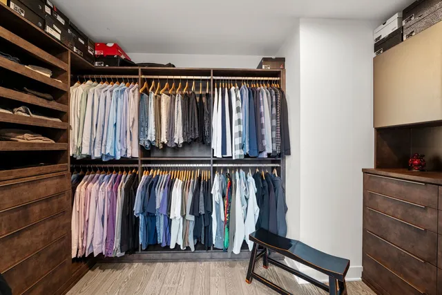 a view of walk in closet with clothes and shoes
