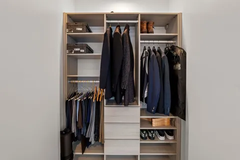 a view of walk in closet with clothes and shoes
