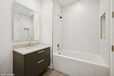 a bathroom with a tub sink and mirror