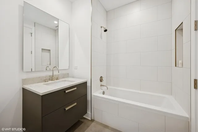 a bathroom with a tub sink and mirror