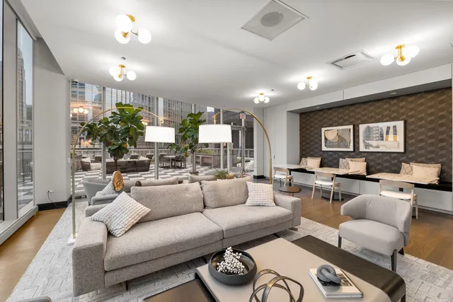 a living room with furniture kitchen view and a large window