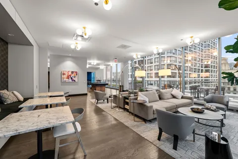 a living room with furniture kitchen view and a chandelier