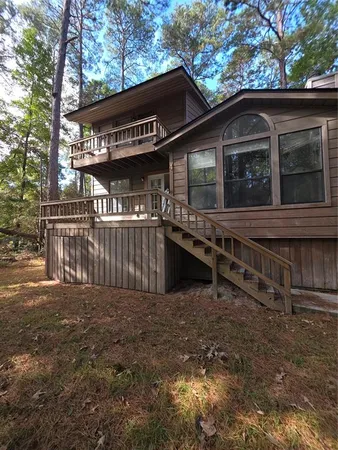 a view of a house with a large window and wooden fence
