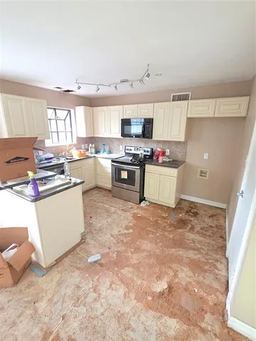 a kitchen with a stove a sink and a cabinets