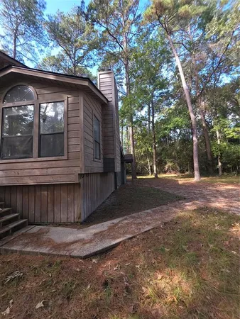 a view of backyard with wooden fence and large trees