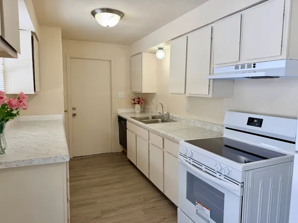 a kitchen with granite countertop white cabinets and a sink