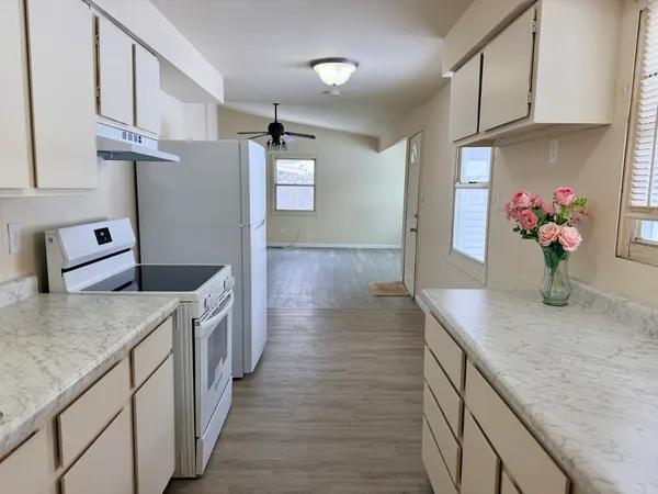 a kitchen with stainless steel appliances granite countertop a sink dishwasher stove and refrigerator