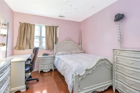 a bedroom with a bed a desk and chair with the walls