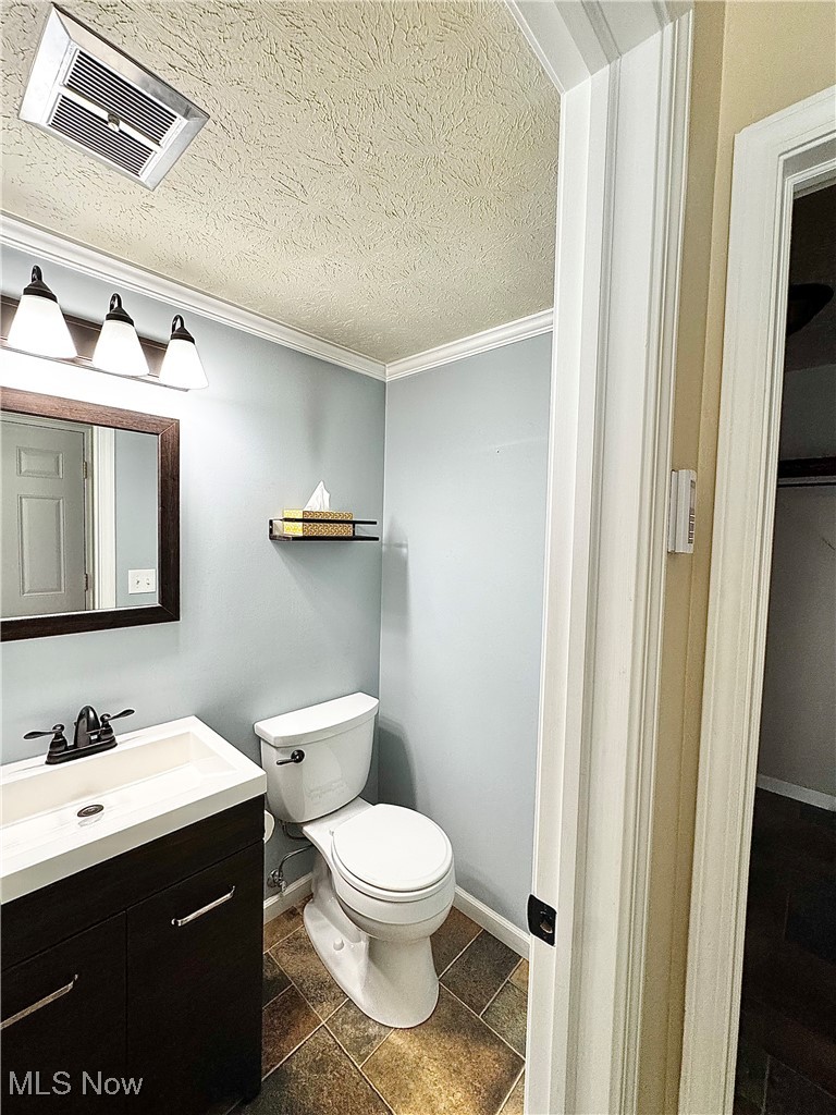7050 Chillicothe Road, Unit B18 Mentor, OH 44060 - Photo 9 of 24 Bathroom featuring vanity, a textured ceiling, and crown molding