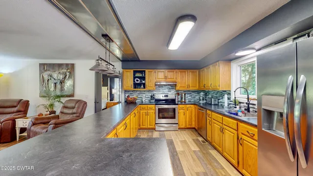 a large kitchen with stainless steel appliances granite countertop a lot of counter space