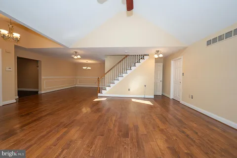 an empty room with wooden floor fireplace and cabinet