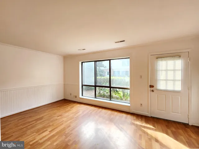 a view of an empty room with wooden floor