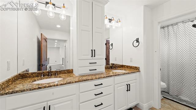 13625 Random Ridge View Colorado Springs, CO 80921 - Photo 34 of 50 Bathroom with double vanity and a shower with shower curtain