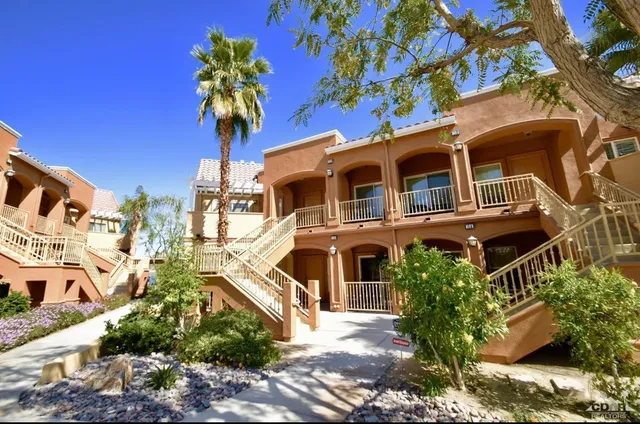 a front view of a house with a yard and potted plants