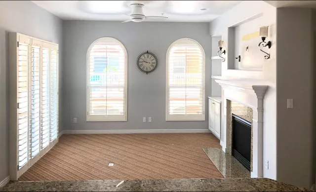 a view of empty room with fireplace and windows