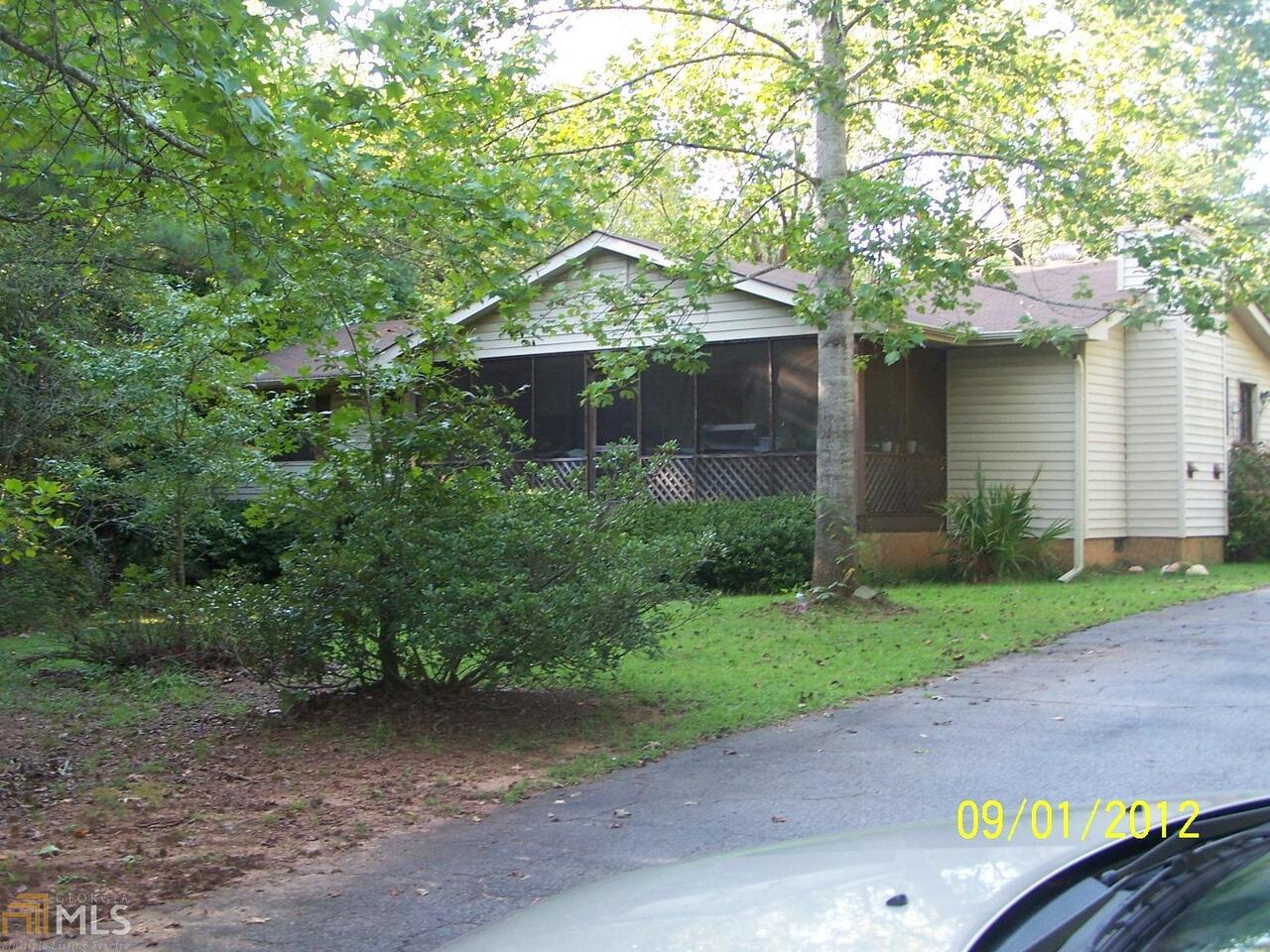a view of a yard in front of a house with large trees