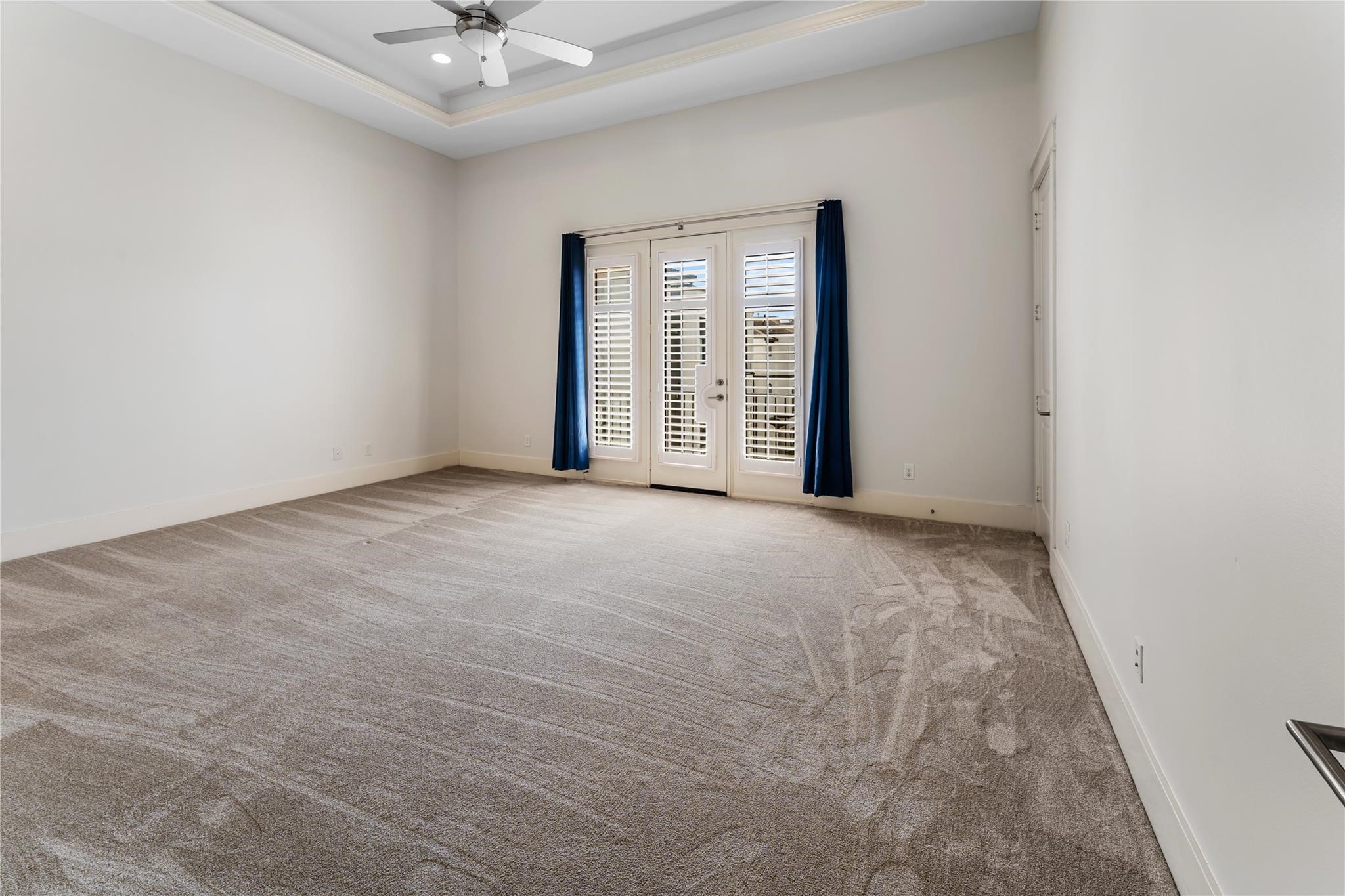 4938 Edison Park Lane Houston, TX 77081 - Photo 32 of 49 The spacious primary suite
offers a serene retreat on the
third floor, complete with plush
carpeting and elevated tray
ceilings. A private balcony
extends the space outdoors,
creating a peaceful setting to
unwind.