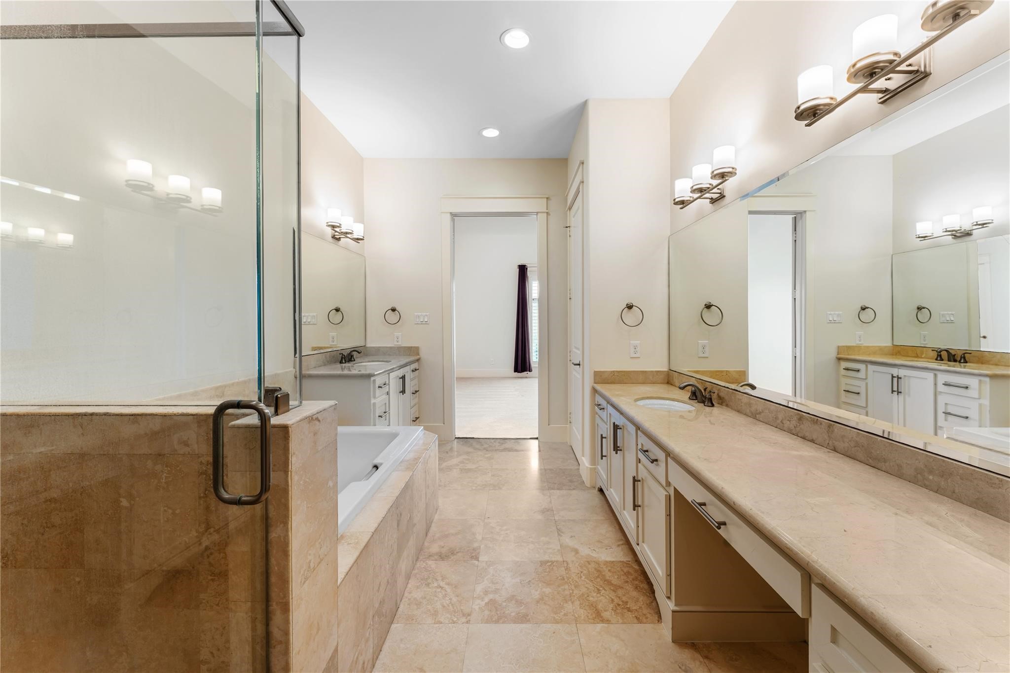 4938 Edison Park Lane Houston, TX 77081 - Photo 37 of 49 a large bathroom with a double vanity sink a mirror a bathtub and shower