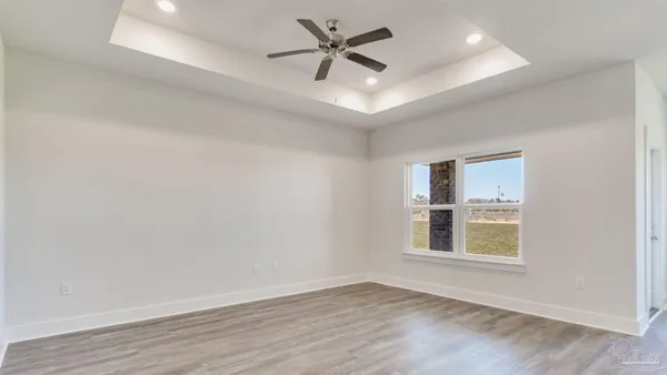 an empty room with window and ceiling fan