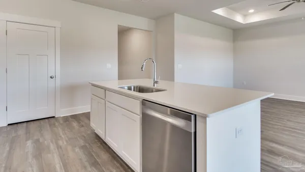 a kitchen with a sink cabinets and wooden floor