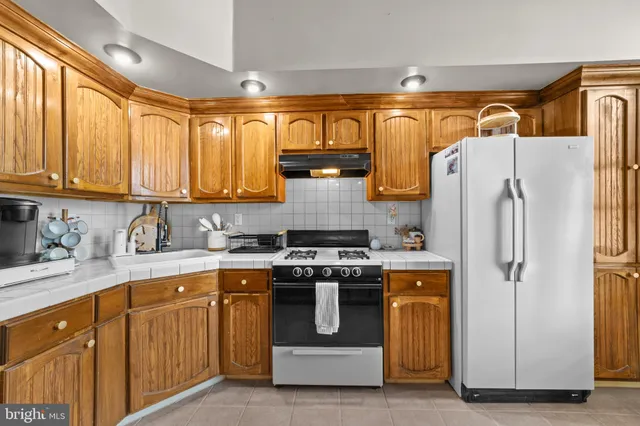 a kitchen with stainless steel appliances granite countertop a refrigerator and a stove