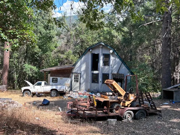 a front view of a house with cars parked
