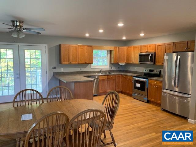 344 High Ridge Road Stanardsville, VA 22973 - Photo 7 of 9 a kitchen with stainless steel appliances granite countertop a table chairs sink refrigerator and microwave