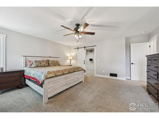 a bedroom with a bed and a ceiling fan