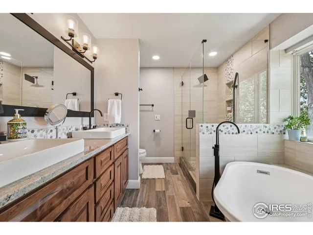 a bathroom with a tub a sink a mirror and a shower