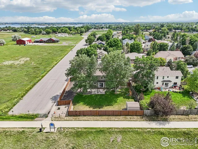 an aerial view of a house with a yard and lake view in back