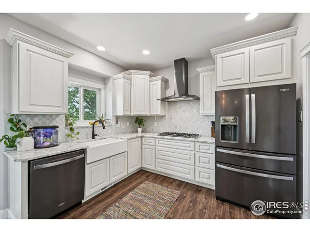 a kitchen with granite countertop stainless steel appliances a sink cabinets and a window