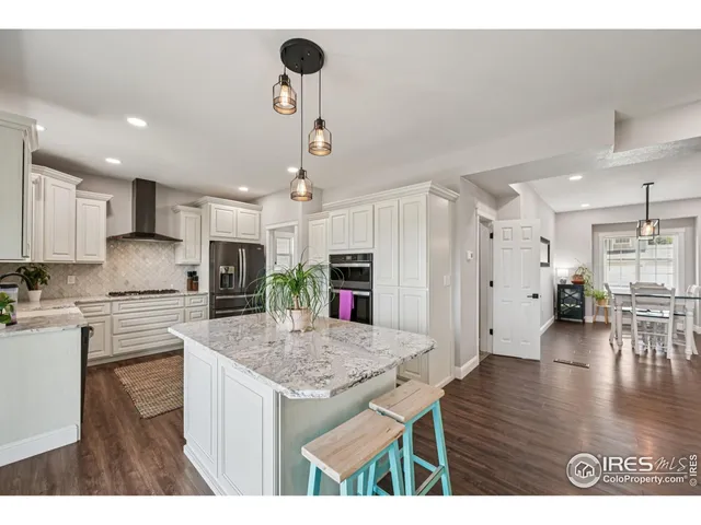 a kitchen with stainless steel appliances granite countertop kitchen island wooden floors and granite counter tops