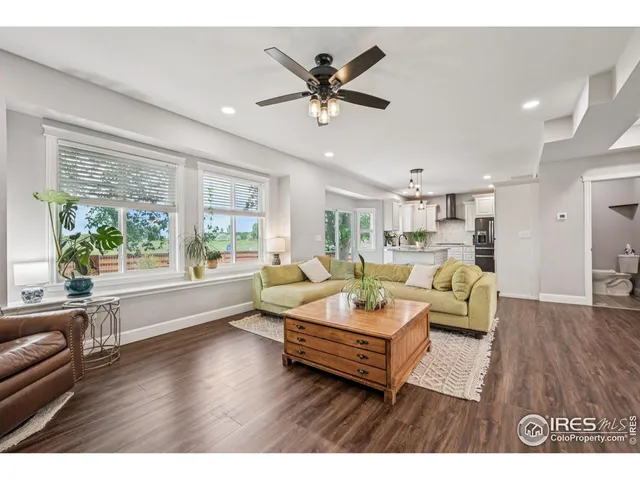 a living room with furniture and a large window with wooden floor