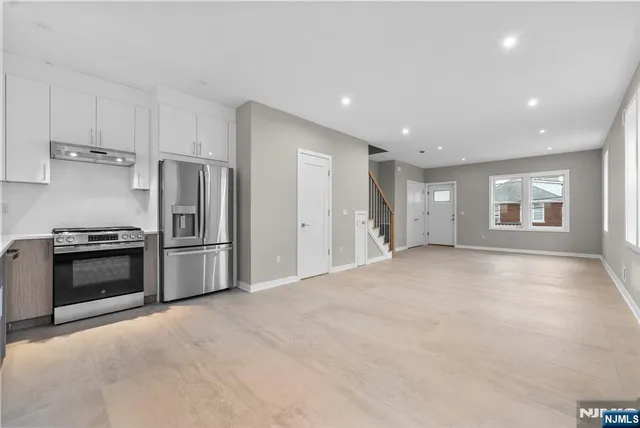 a view of a kitchen with a stove cabinets and stainless steel appliances