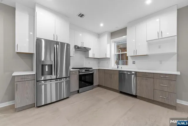 a kitchen with granite countertop stainless steel appliances and refrigerator
