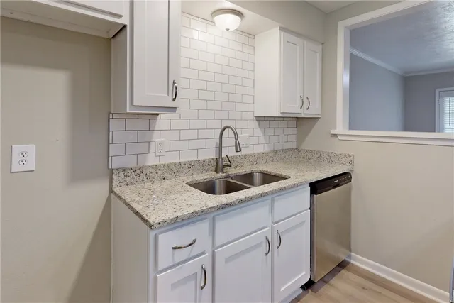 a kitchen with granite countertop a sink and stainless steel appliances
