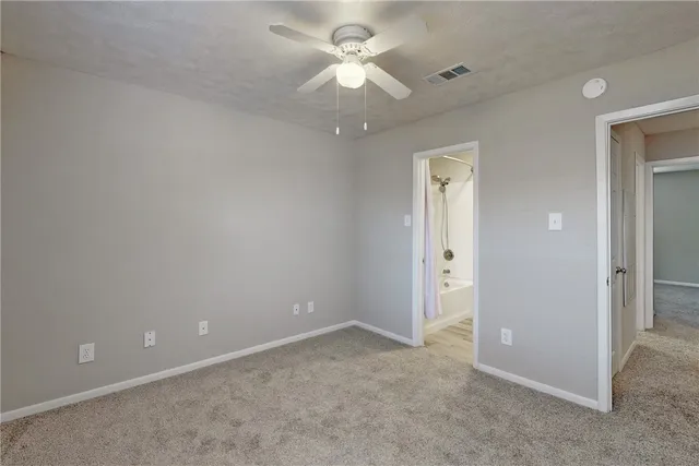 an empty room with a window and a ceiling fan