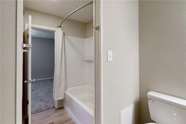 a view of an empty room and a chandelier fan