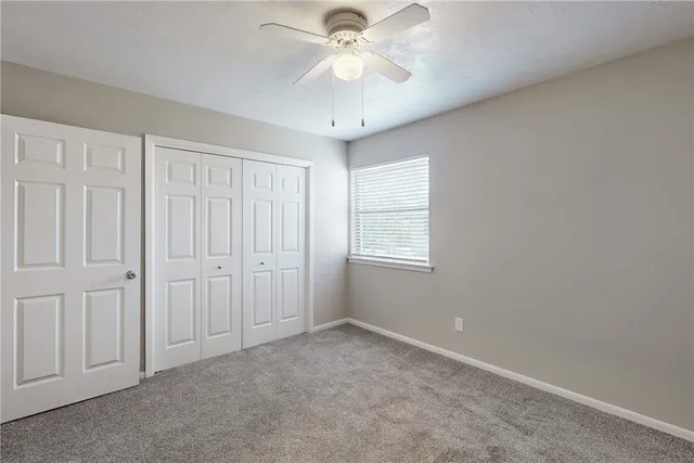 a bathroom with a granite countertop sink vanity mirror and toilet