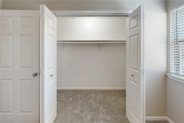 an empty room with a ceiling fan and a window