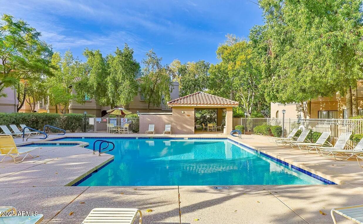 a view of a swimming pool with a patio and a yard