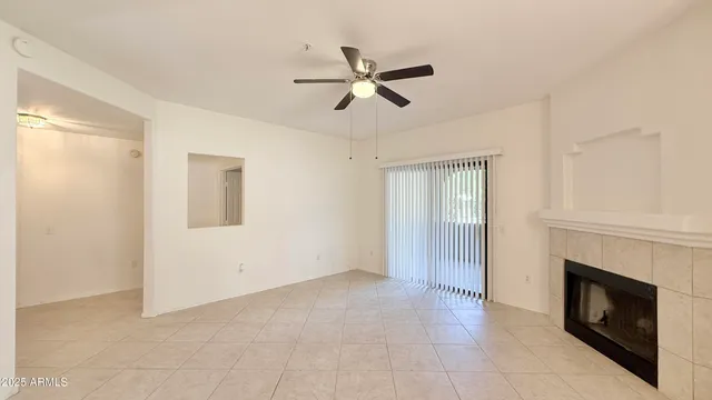 a view of empty room with fireplace and fan
