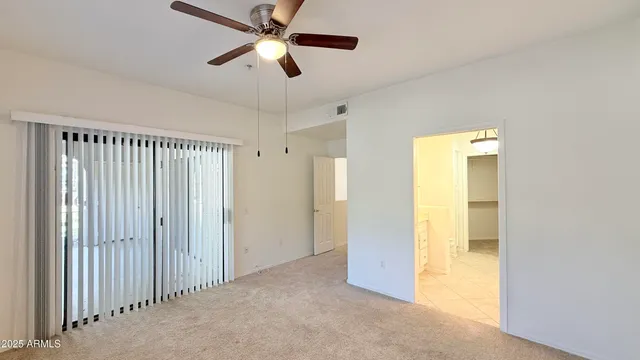 an empty room with a ceiling fan and a window