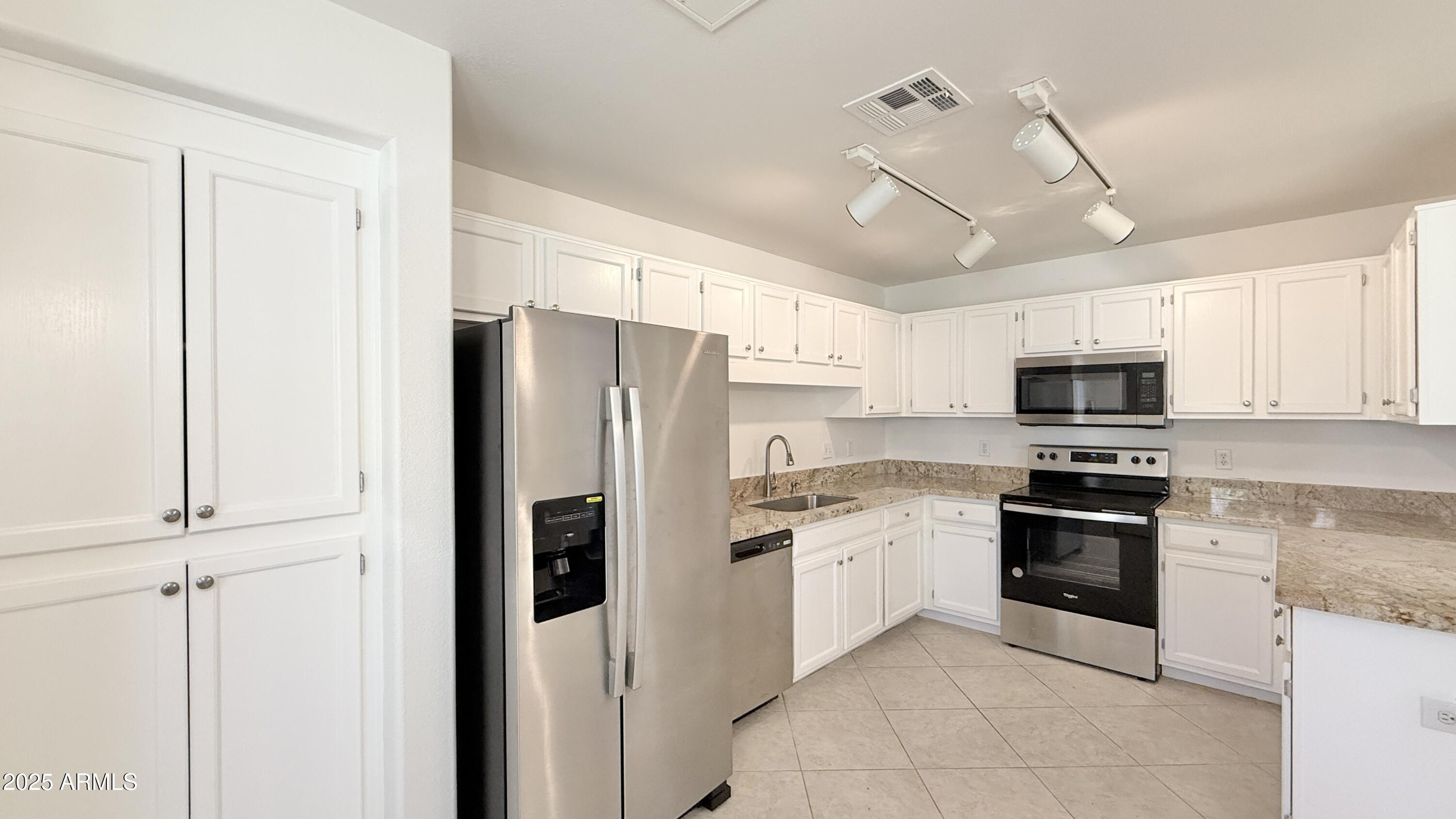 15050 North Thompson Peak Parkway, Unit 1012 Scottsdale, AZ 85260 - Photo 2 of 49 a kitchen with stainless steel appliances granite countertop a refrigerator a stove a microwave oven with white cabinets