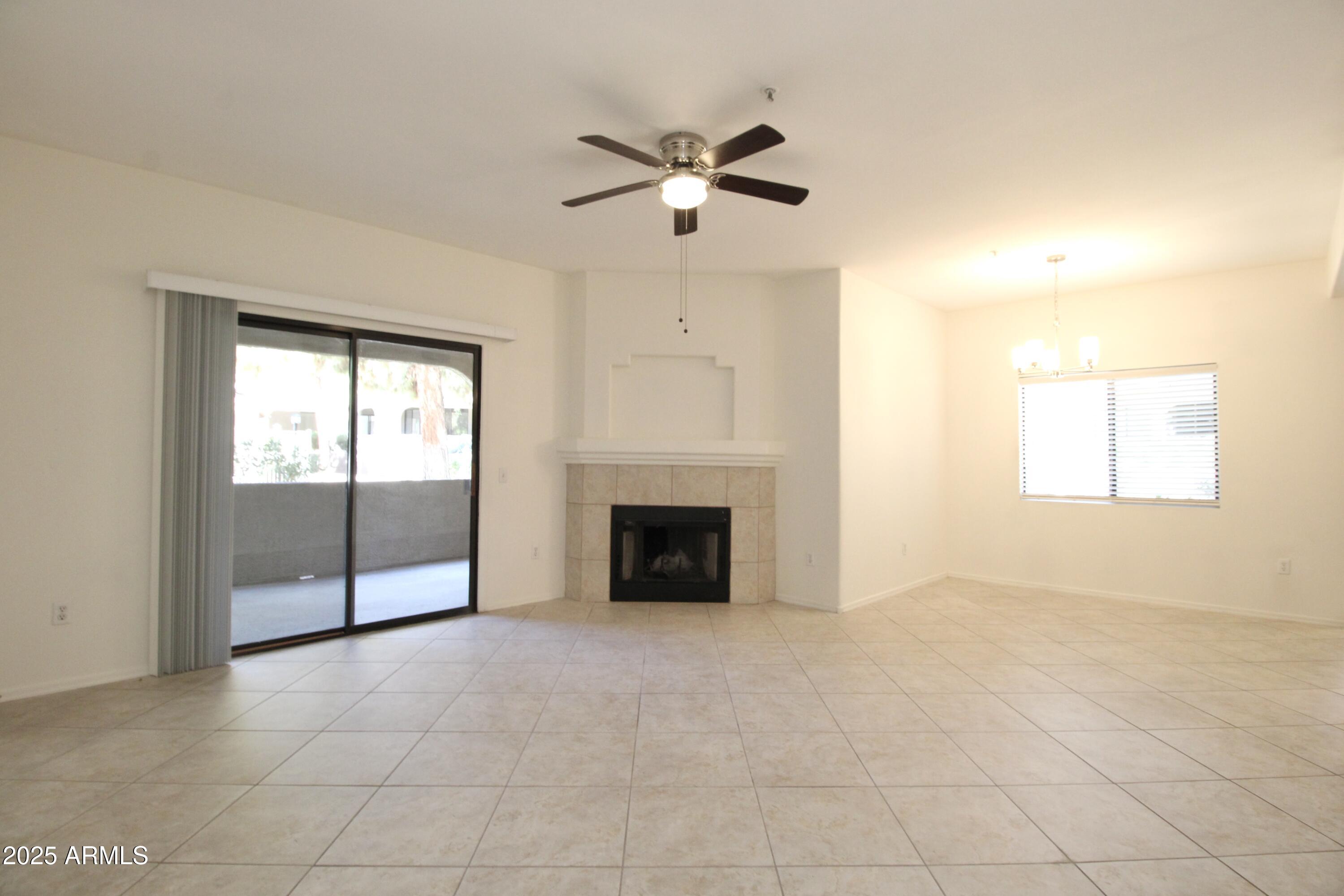 15050 North Thompson Peak Parkway, Unit 1012 Scottsdale, AZ 85260 - Photo 21 of 49 an empty room with fireplace and windows