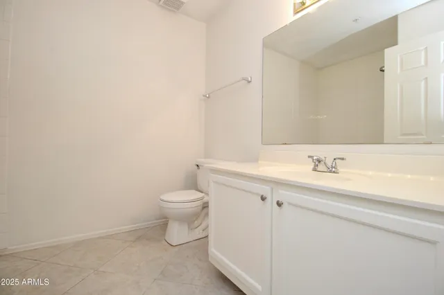 a bathroom with a granite countertop toilet and sink