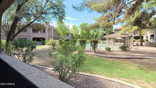 a view of a house with a garden and trees